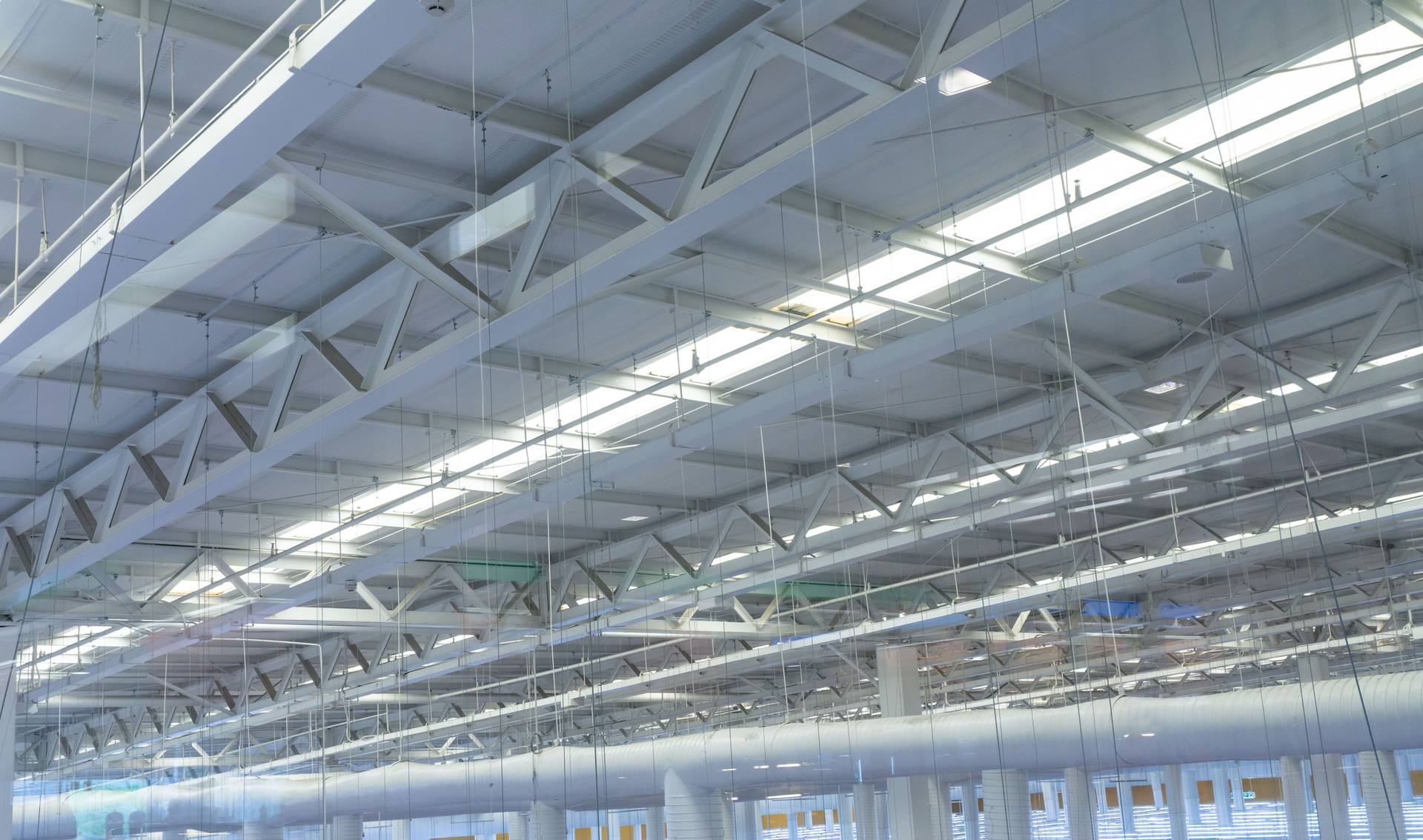 Modern Industrial Warehouse Interior with Open Ceiling Structure and Skylights